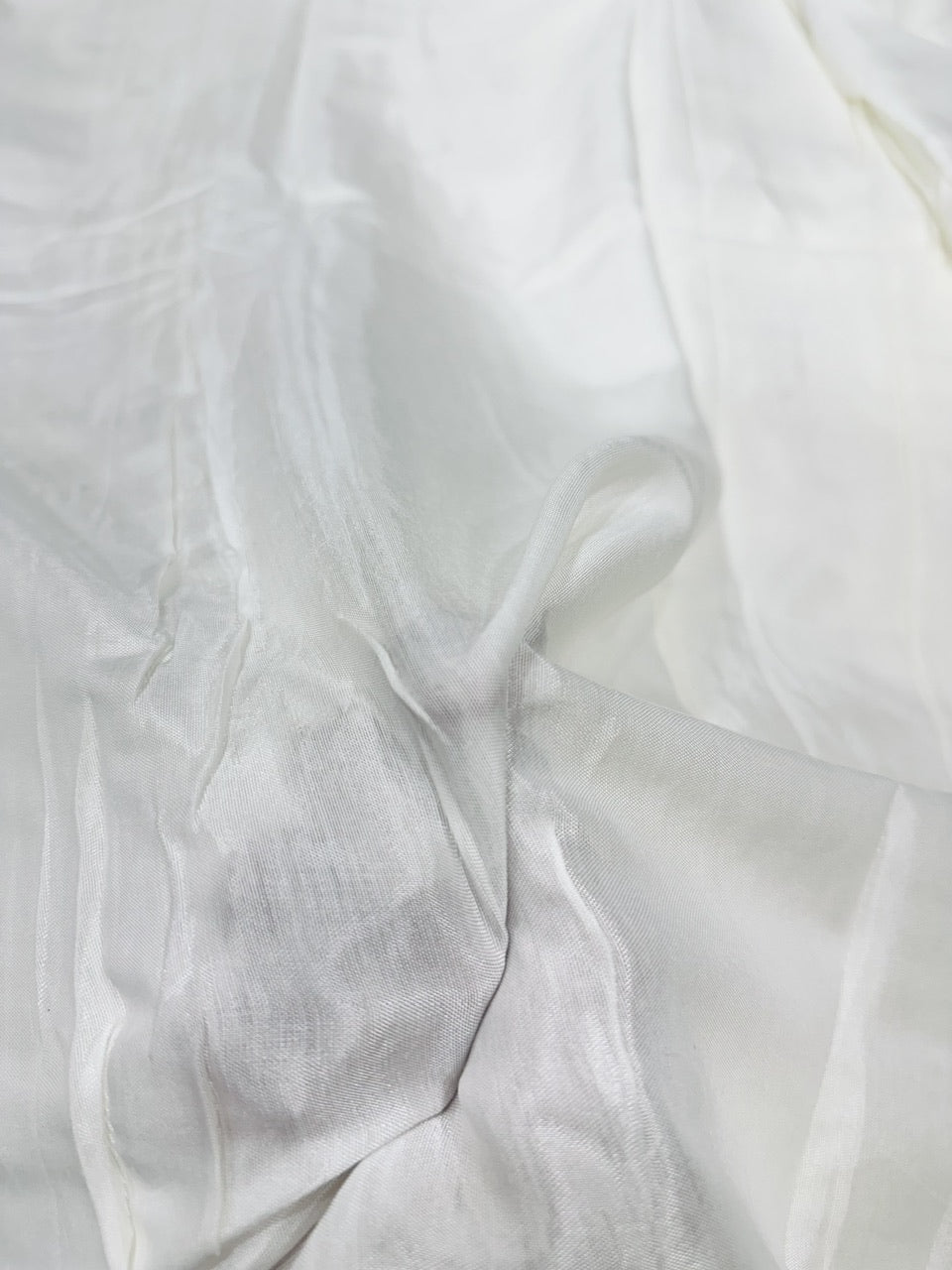 Close-up of white shantoon fabric with folds