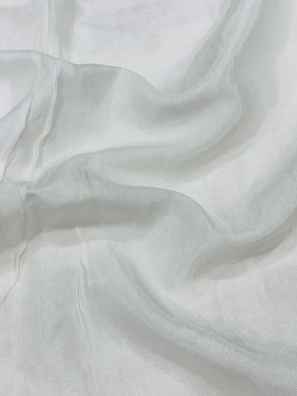 Close-up of white shantoon fabric with folds