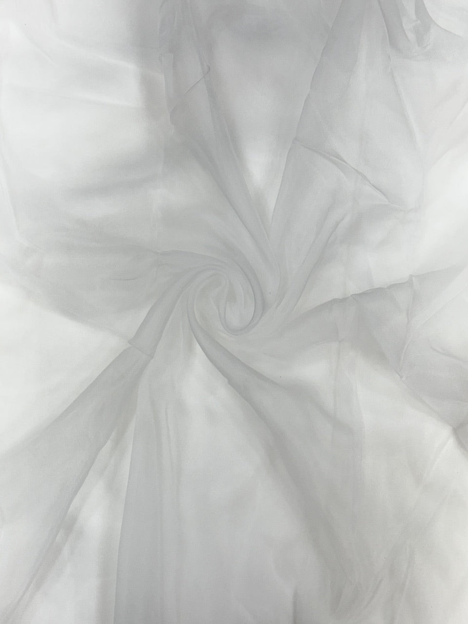Close-up of white organza fabric with a swirling pattern