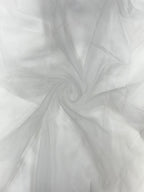 Close-up of white organza fabric with a swirling pattern