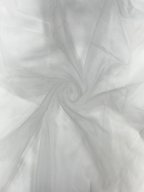 Close-up of white organza fabric with a swirling pattern