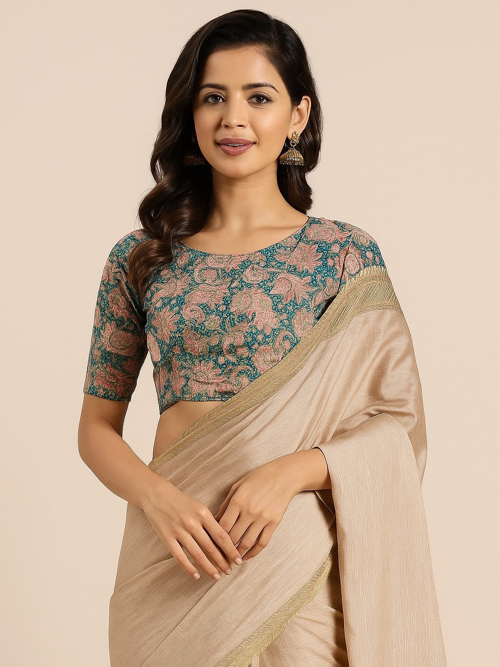 Woman wearing a floral blouse and beige saree against a beige background