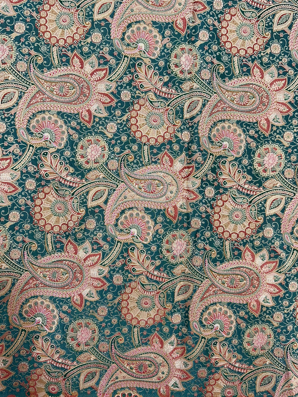 Patterned fabric with paisley design on a green background