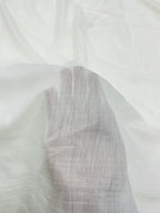 Close-up of a textured white mul mul chanderi fabric with a subtle pattern