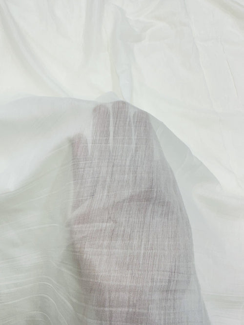Close-up of a textured white mul mul chanderi fabric with a subtle pattern
