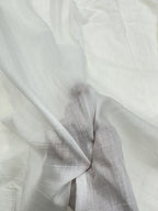 Close-up of hand holding white mul Chanderi fabric with subtle texture