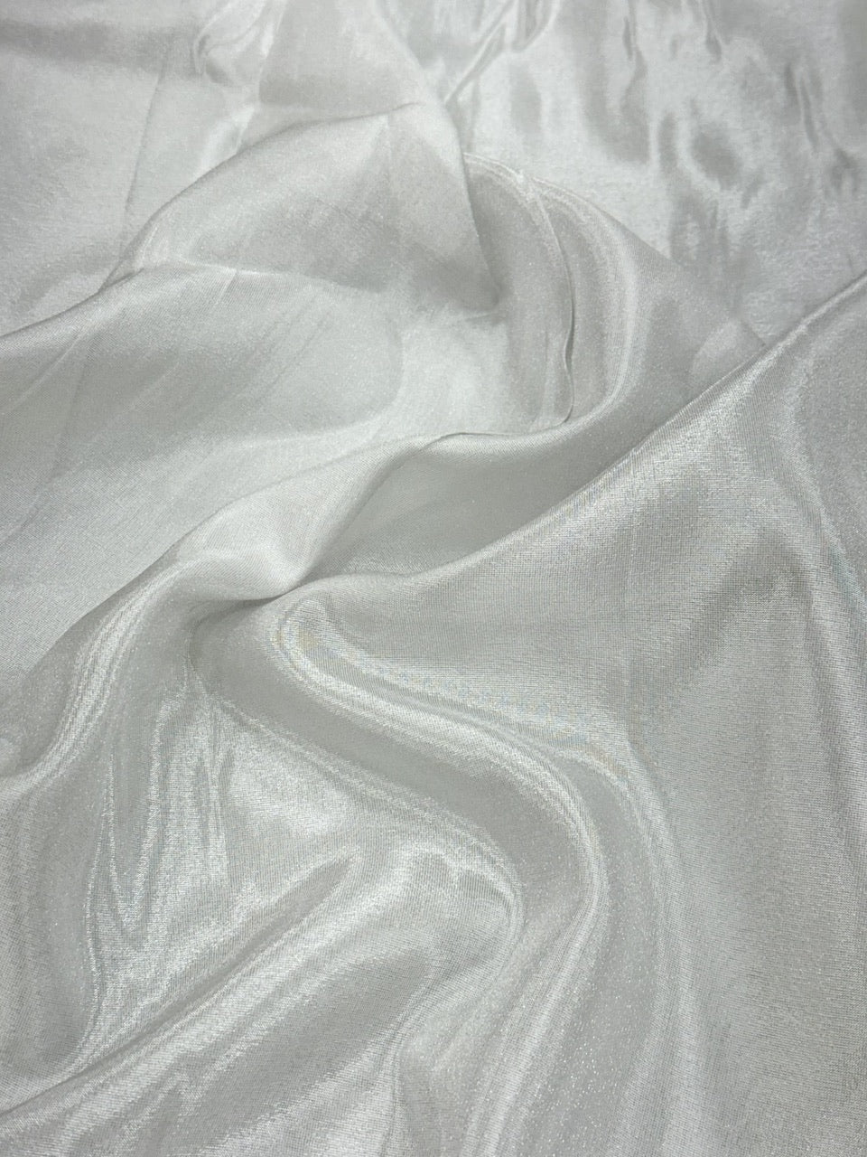 Close-up of silver shimmer tissue fabric with a textured pattern