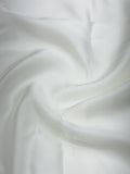 Close-up of pure white satin fabric with soft folds