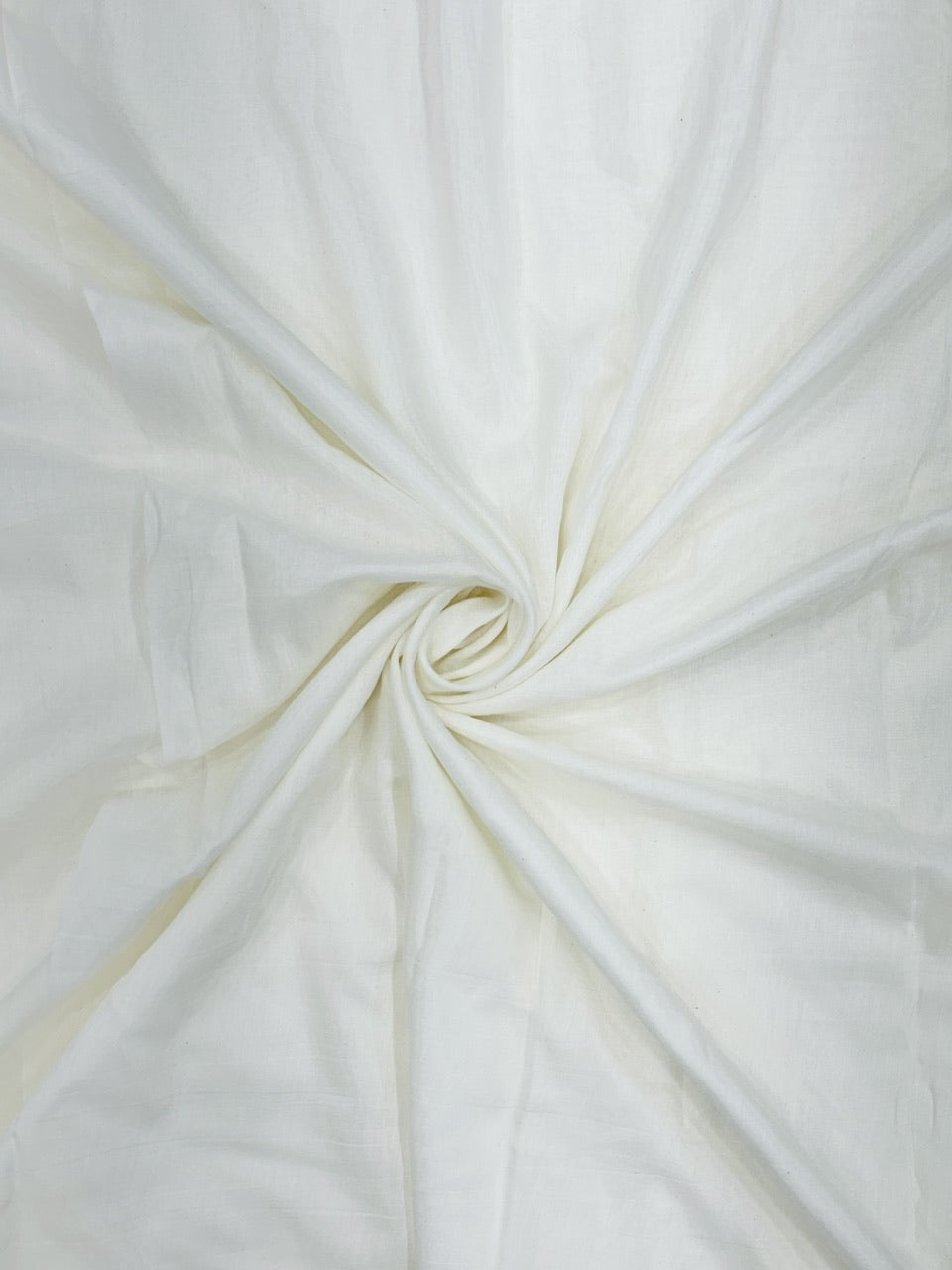 Close-up of white mul chanderi fabric with a swirl pattern