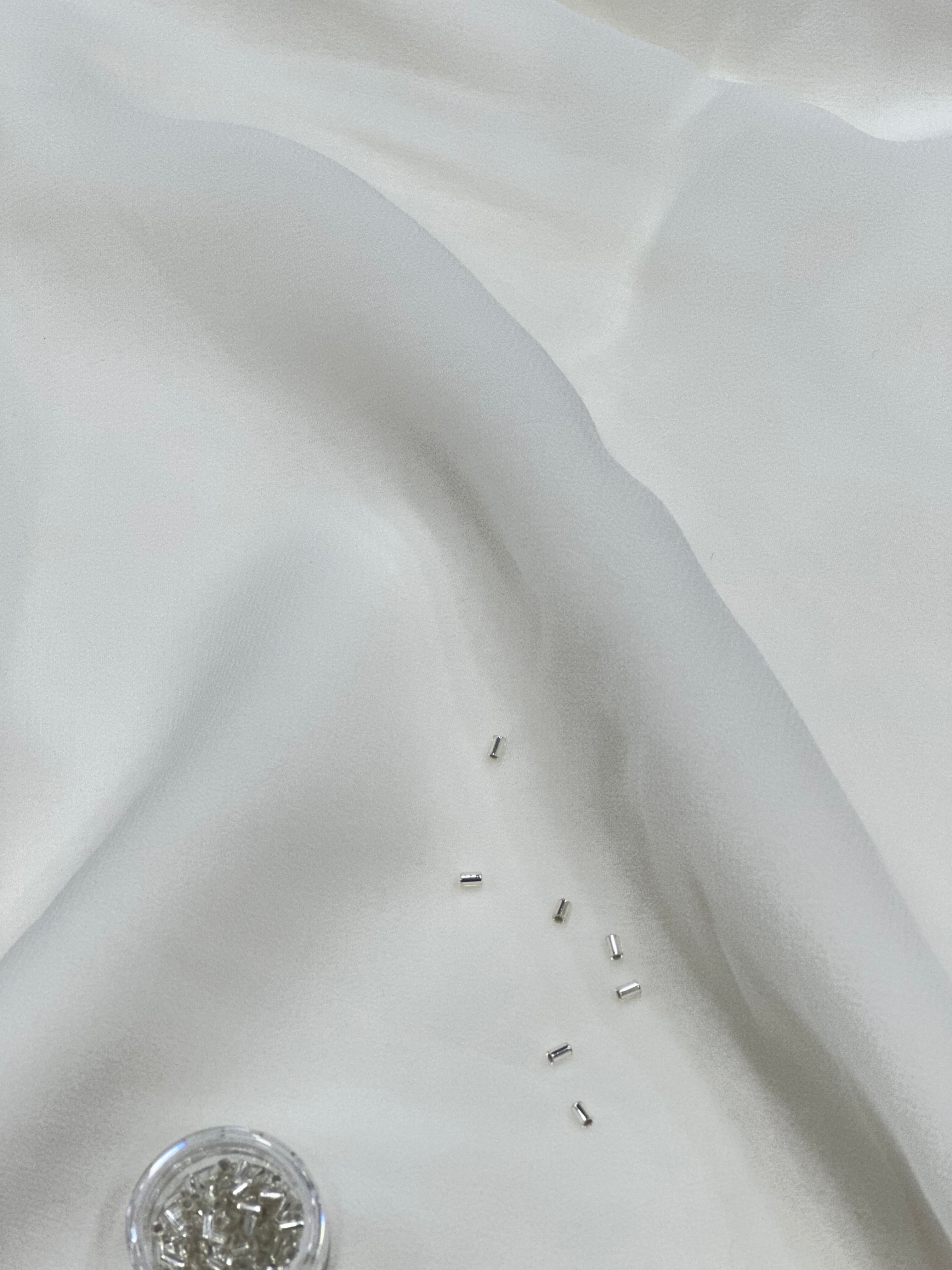Close-up of a white georgette fabric with small beads on it