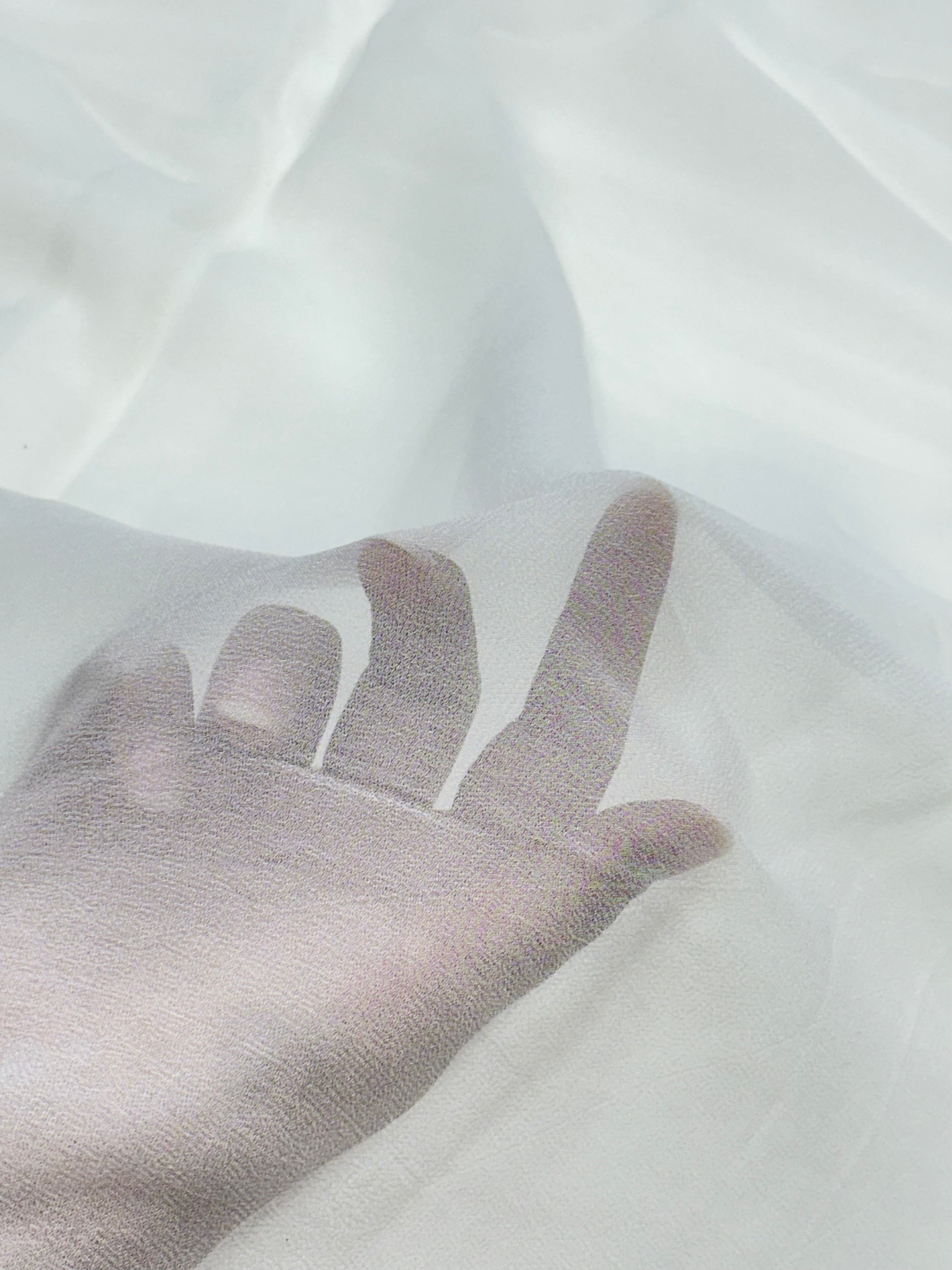 Hand showing texture of a white georgette fabric background