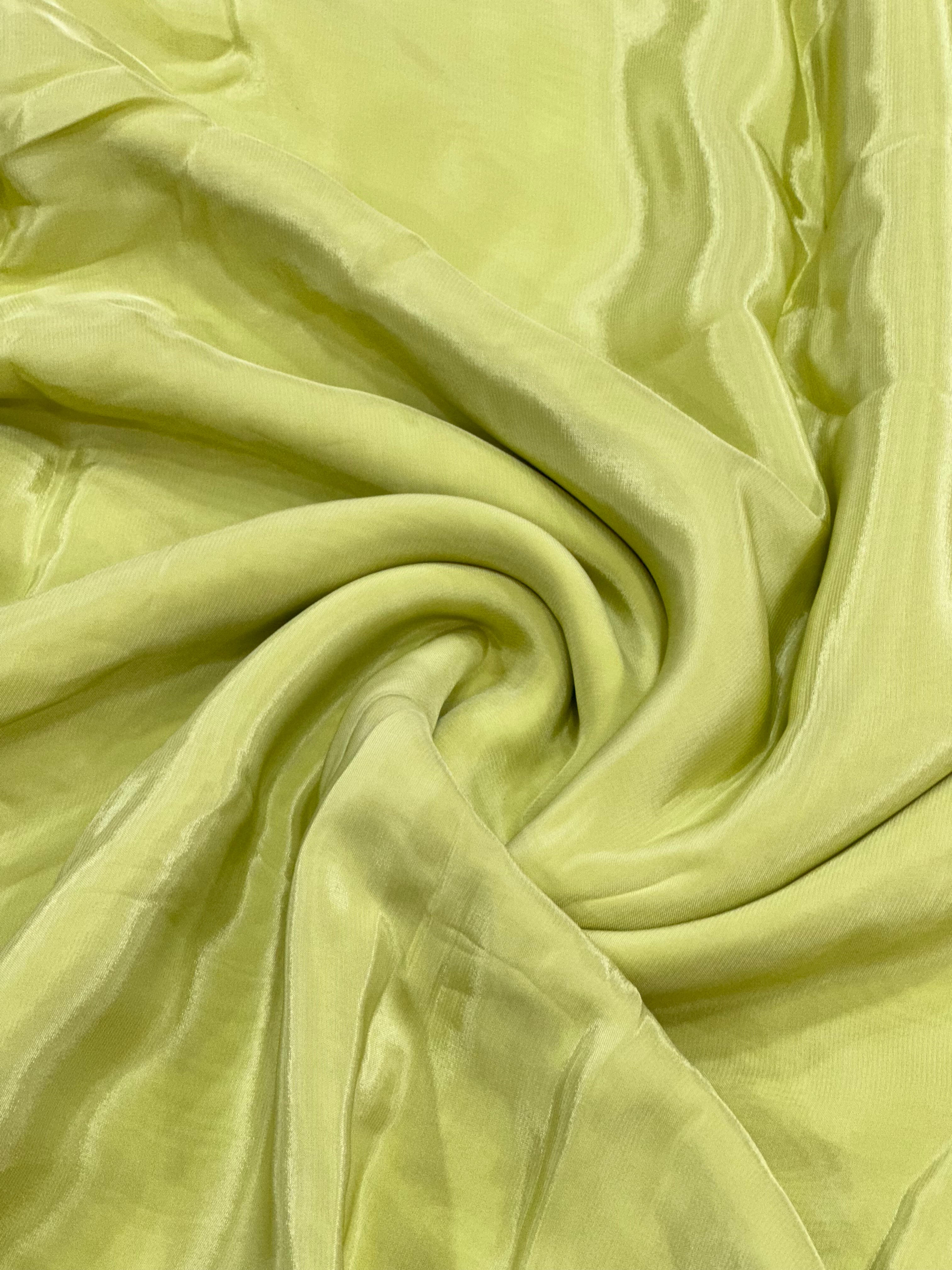 Close-up of lime green natural crepe fabric with folds