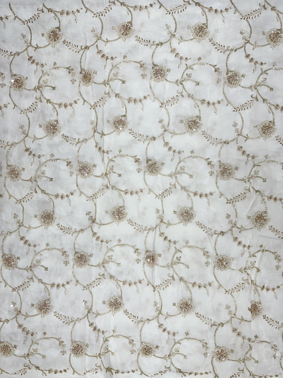 Hand embroidered crepe fabric with circular designs on a white background