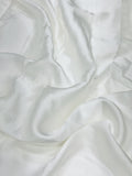 Close-up of white modal satin fabric with folds