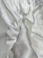 Close-up of white modal satin fabric with folds