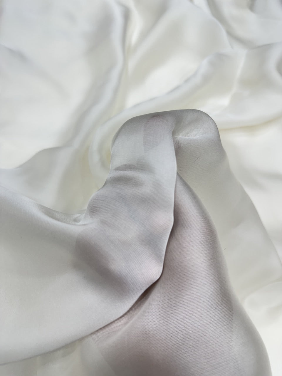 Close-up of white organza satin fabric with folds