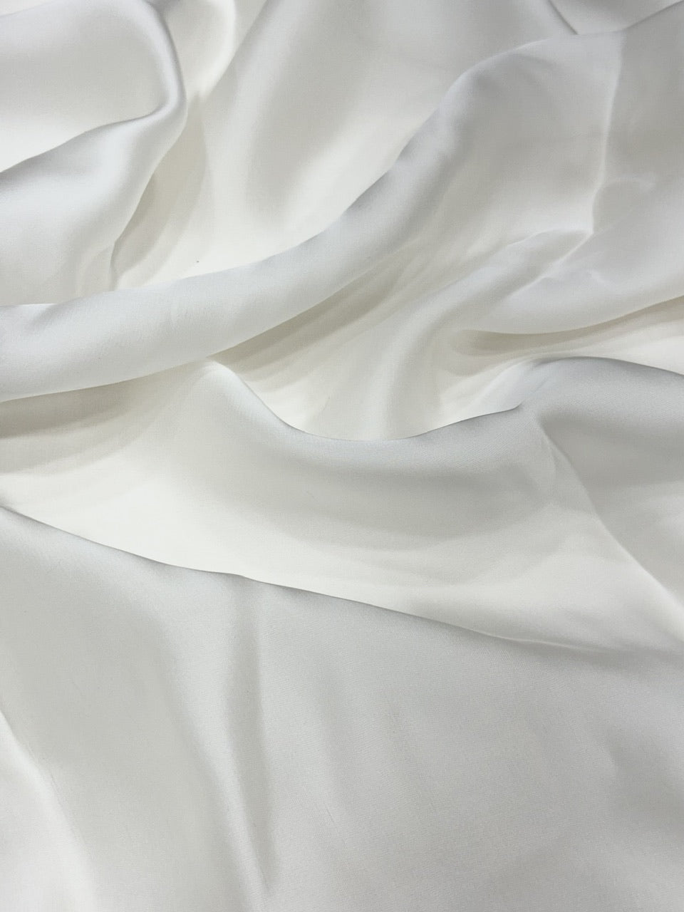 Close-up of white organza satin fabric with soft folds