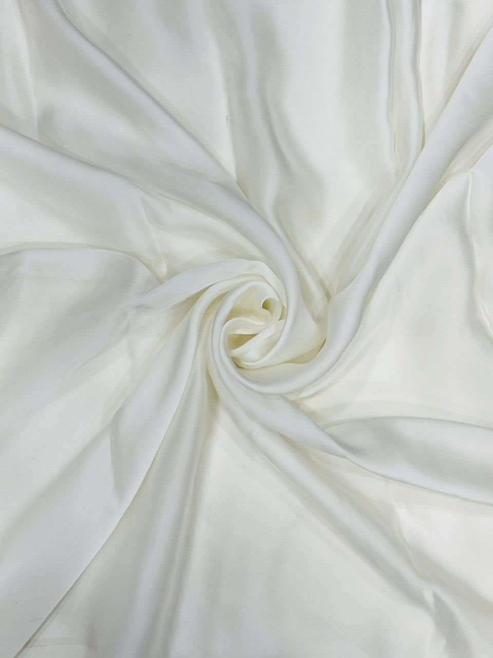 Close-up of white organza satin fabric with folds