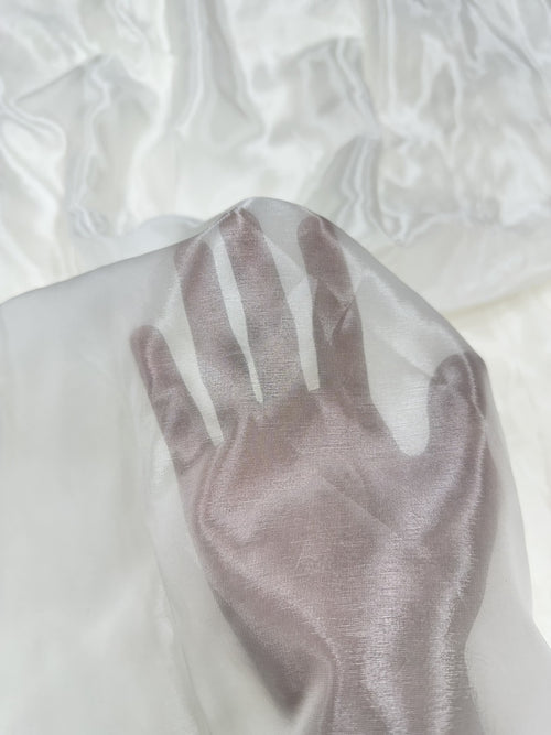 Close-up of a palm on a textured white glass organza fabric