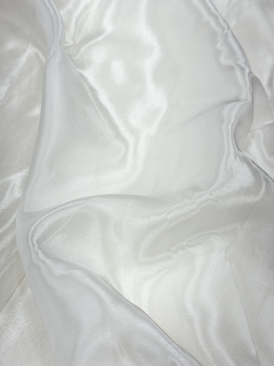 Close-up of white glass organza fabric with folds