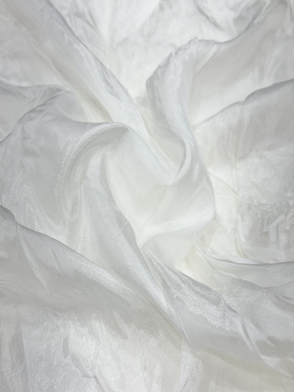 Close-up of white silk fabric with folds