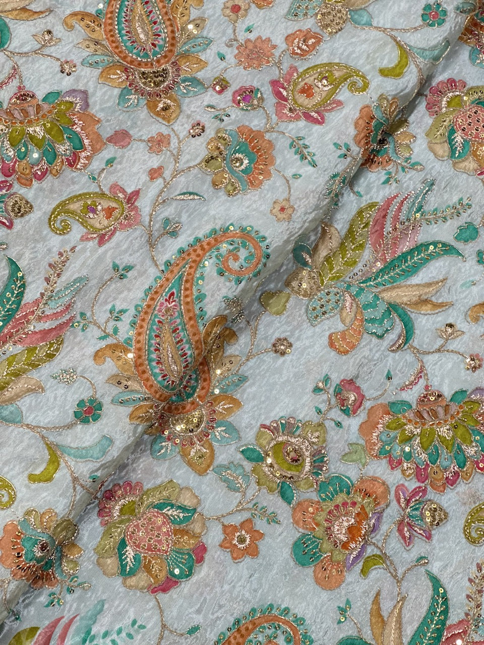 Close-up of intricate floral and paisley patterned fabric.