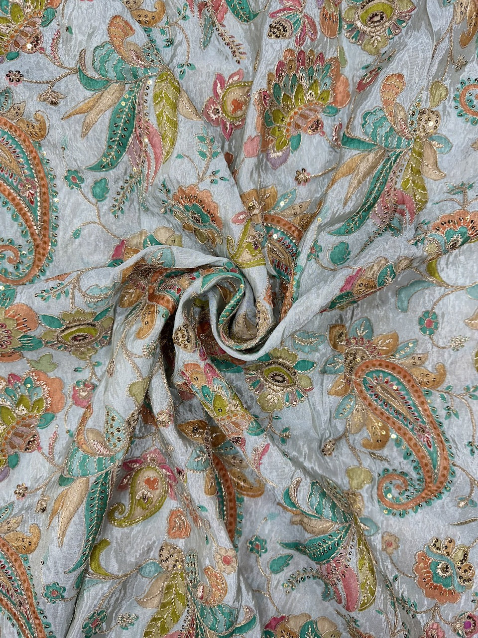 Close-up of paisley patterned fabric with multicolor design on a light background