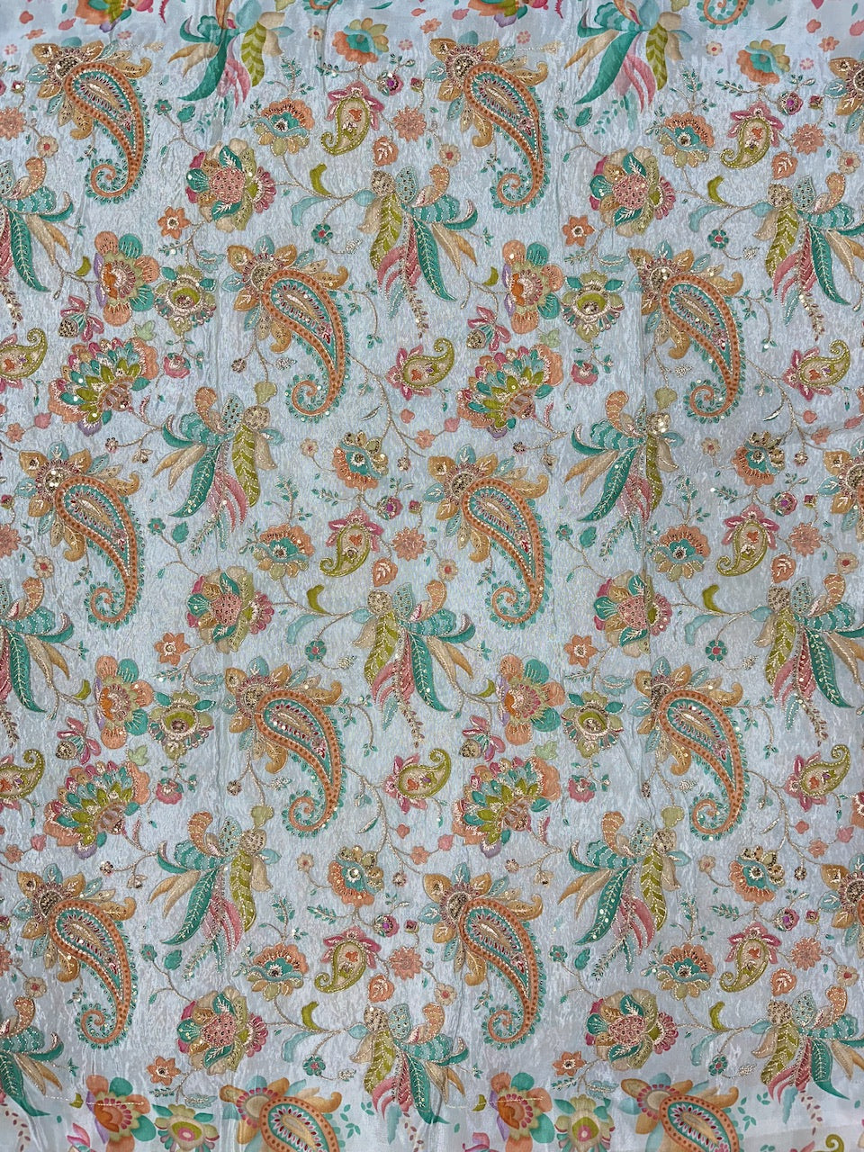 Patterned fabric with colorful paisley design on a light blue background
