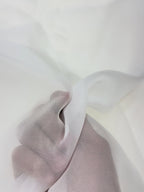 Close-up of a hand holding a white organza fabric against a white background