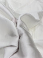 Close-up of white modal satin fabric with folds