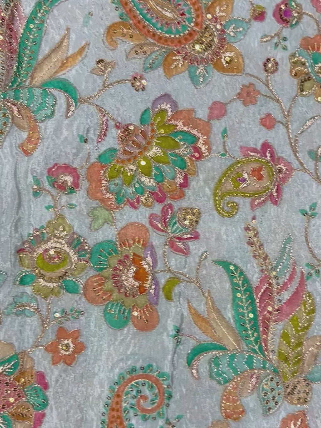 Close-up of intricate floral and paisley patterned fabric.