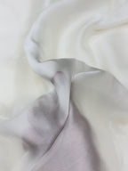 Close-up of white fabric with a hand on a white organza satin showing texture