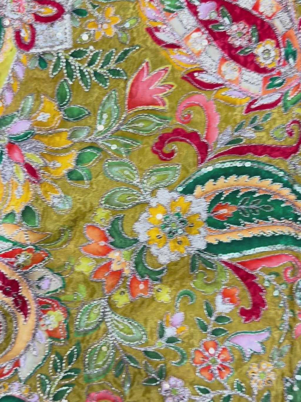Close-up of a colorful embroidered fabric with intricate patterns and vibrant colors.