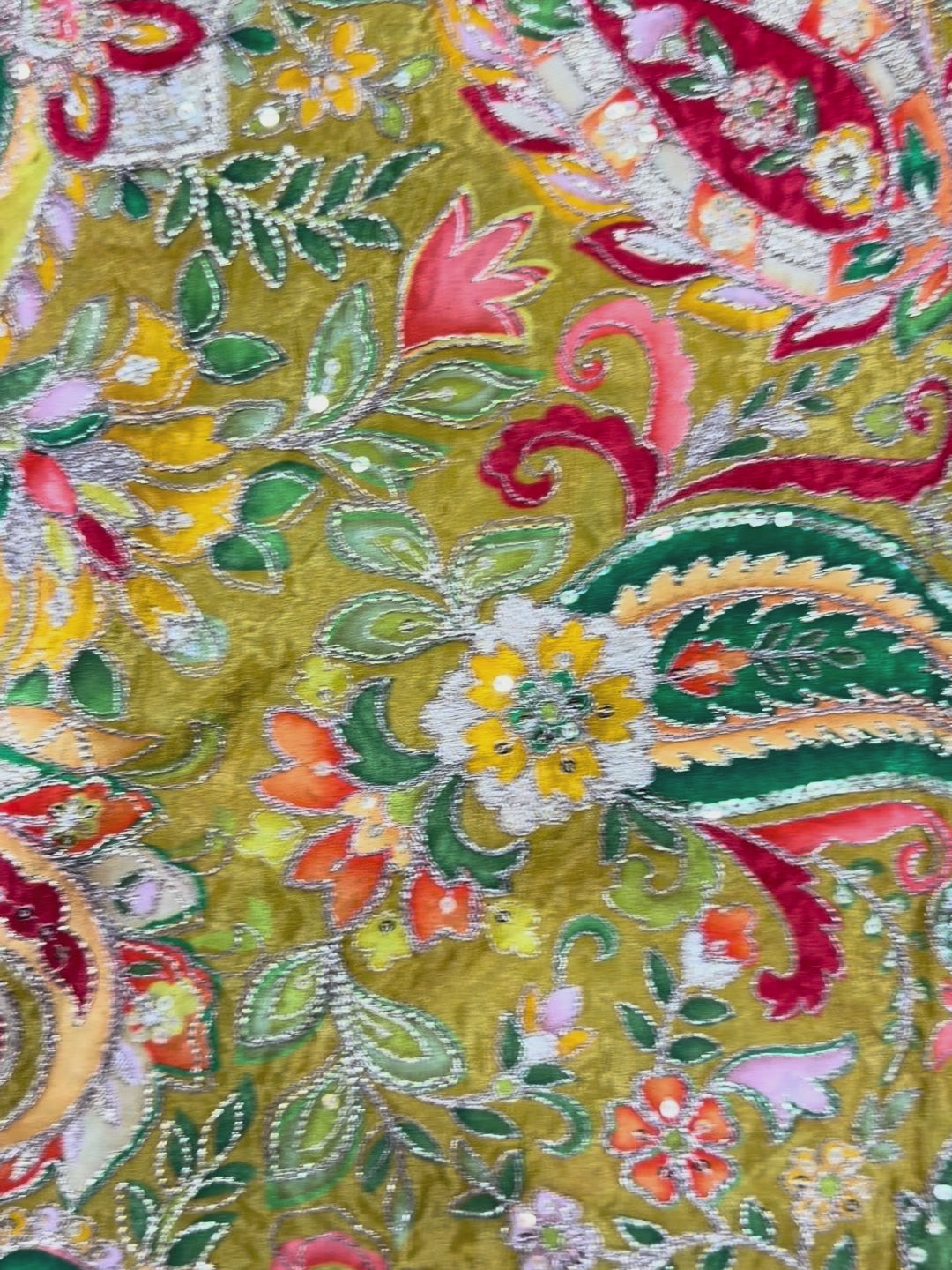 Close-up of a colorful embroidered fabric with intricate patterns and vibrant colors.