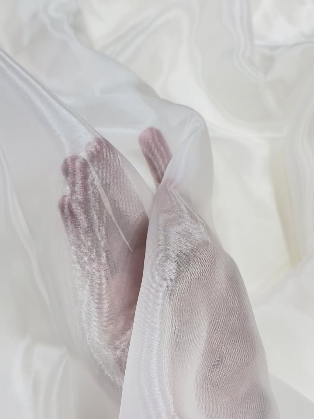 Close-up of a palm on a textured white glass organza fabric